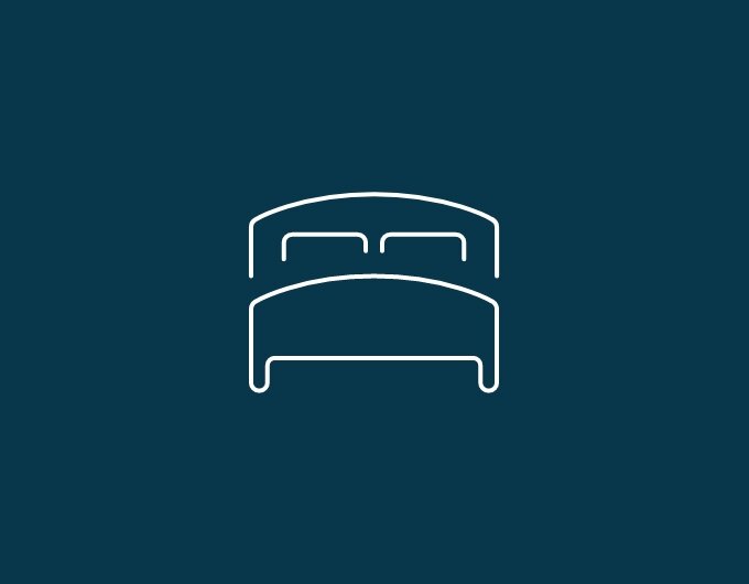 Pictogramme d’un lit avec tête de lit et deux oreillers sur fond bleu foncé