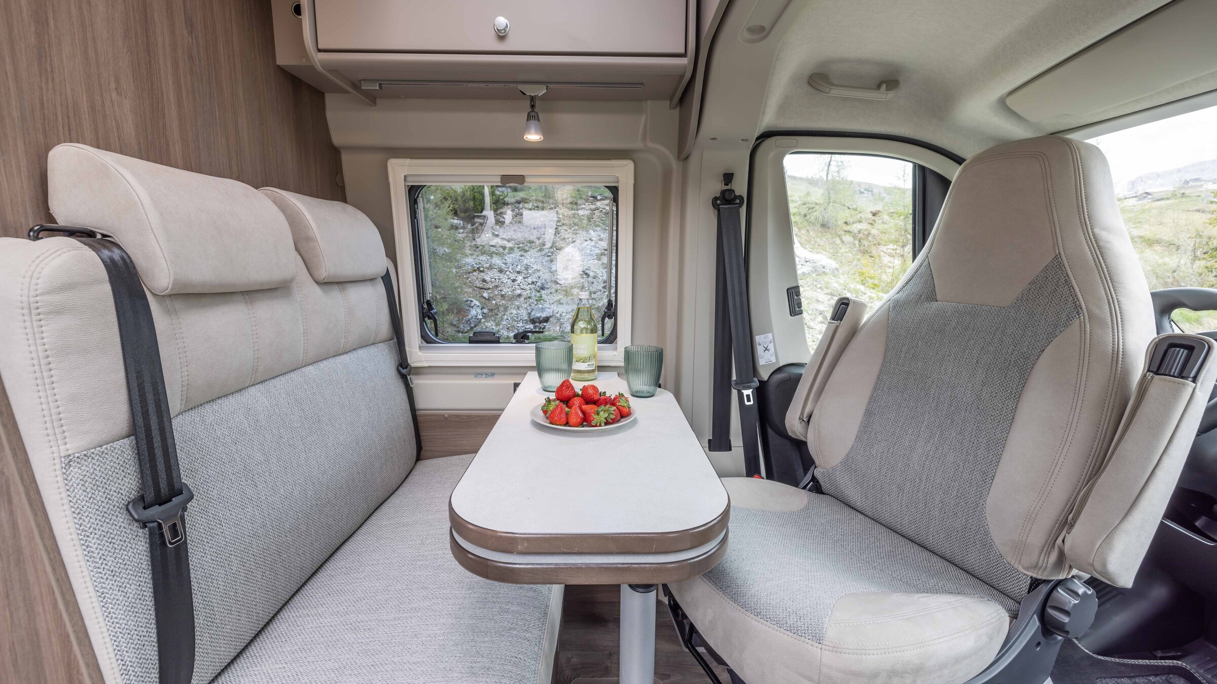 Carado motorhome lounge with table, bench, swivelling front seat and window