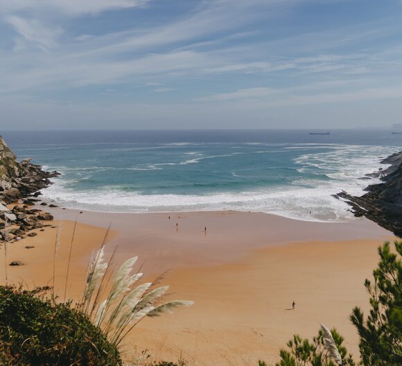 Picturesque bay with sandy beach, rocky cliffs, blue sea, and green vegetation ? ideal for camping trips.