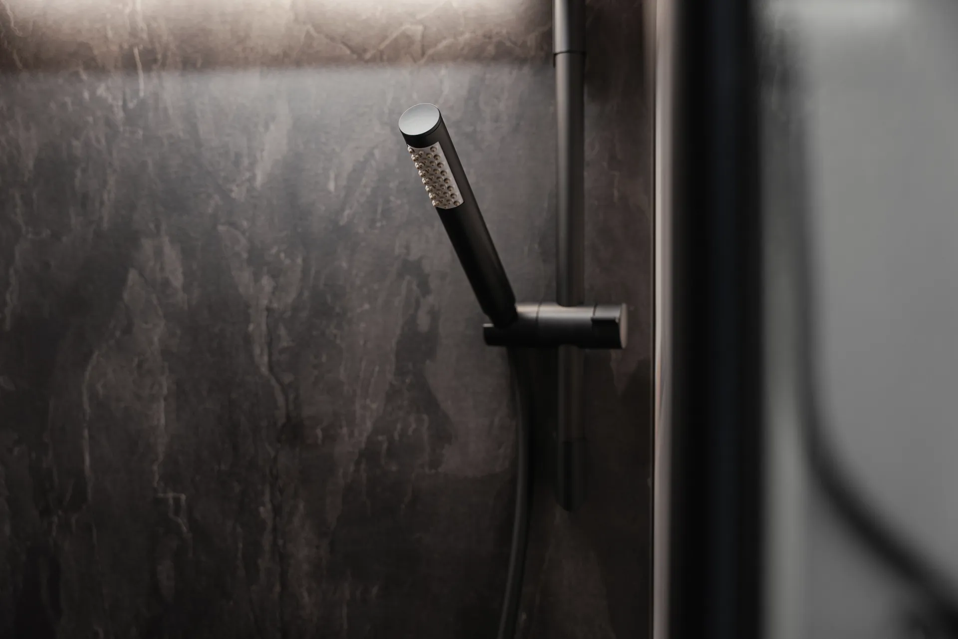 Matt black fittings and premium surfaces give the shower area its modern, architectural character.