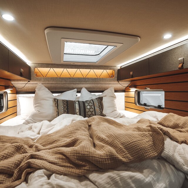 The sleeping area of the HYMER ML-T in the Native Bamboo style invites relaxation.