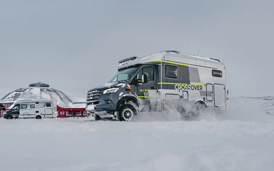 Sidovy av förarsidan på HYMER ML-T CrossOver, fordonet är parkerat i snön, HYMER B-MC T BlackLine i bakgrunden