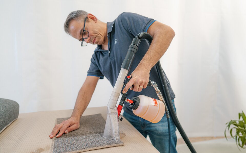Manual cleaning of the floor carpet of the HYMER motorhome with a wet carpet vacuum cleaner